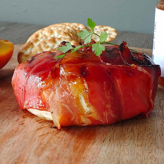 Creamy brie wrapped in crispy prosciutto, topped with fruity jam, tailgating recipe, cookout recipe